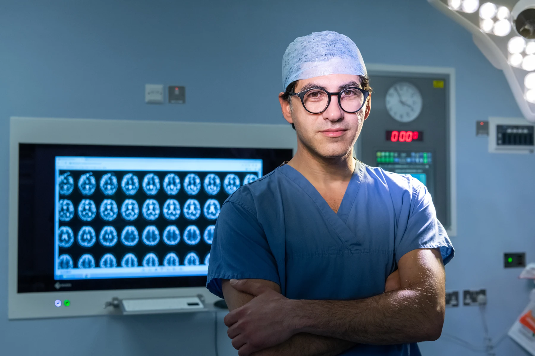 Harith Akram in theatre beside brain imaging